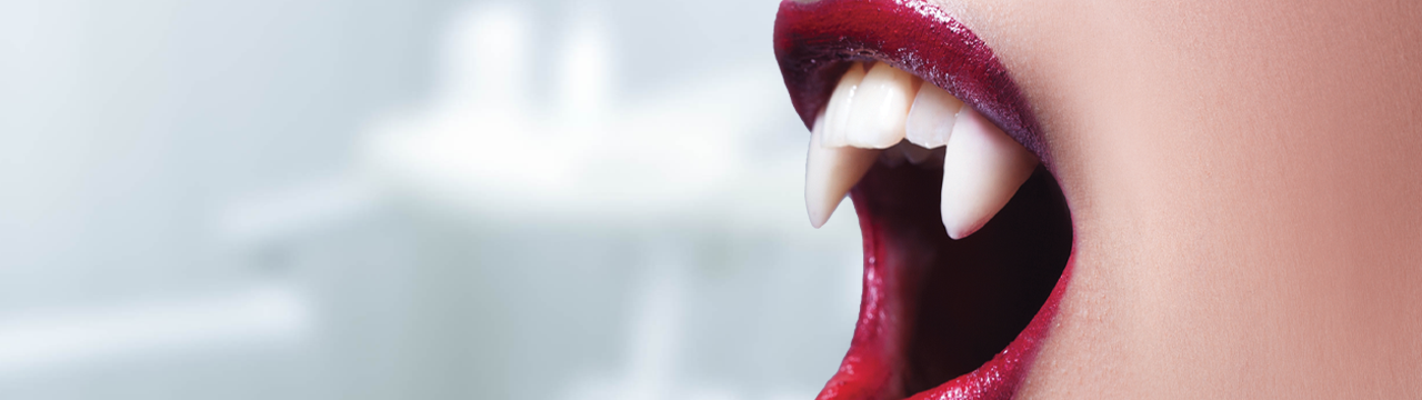 A person wearing vampire teeth.