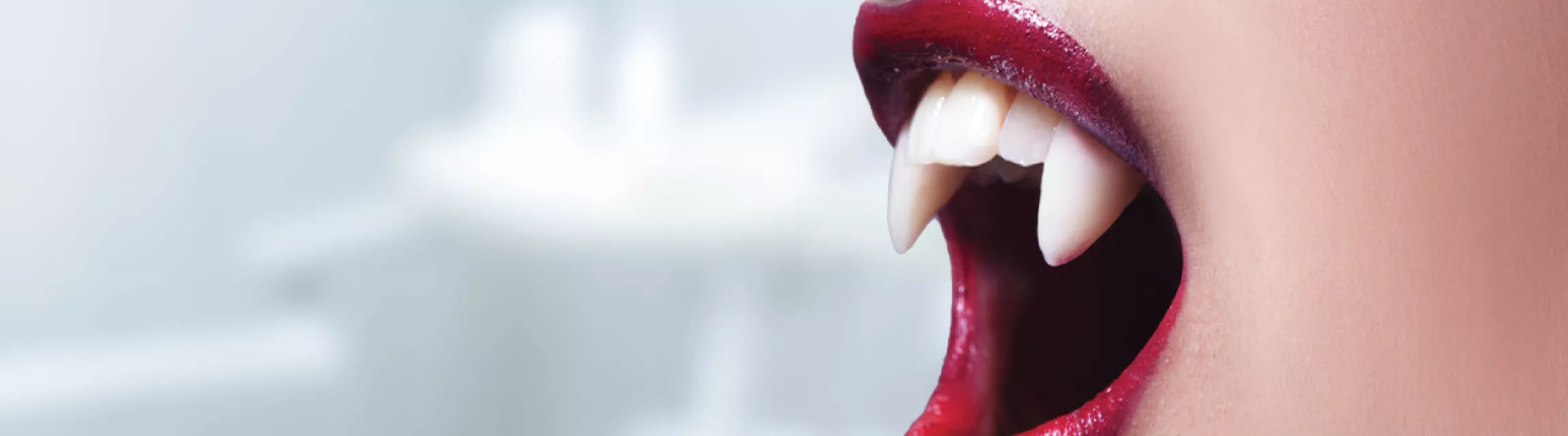 A person wearing vampire teeth.