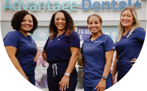 Advantage Dental employees smiling in front of a dental practice.