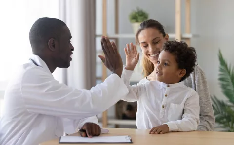 A Dentist high-fiving a patient, creating a positive patient experience at the dental office.