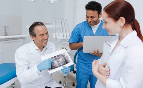 A dental team reviewing a patient's x-ray.