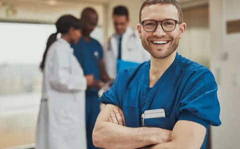 A dentist posing for a smile while at work.