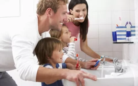 A family brushing their teeth together.