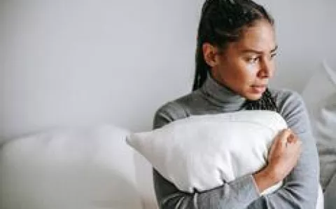 A woman hugging her pillow.
