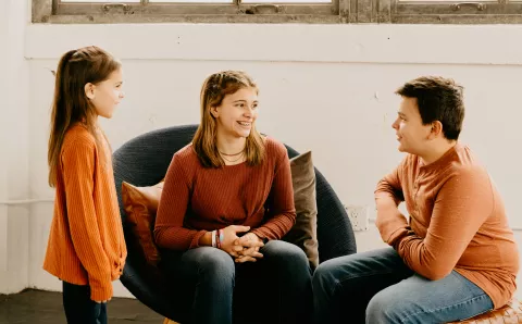 An older sister explaining common dental myths to her two younger siblings.