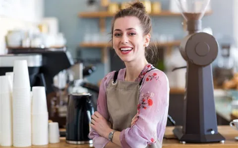 A barista smiling with no coffee or tea teeth stains.
